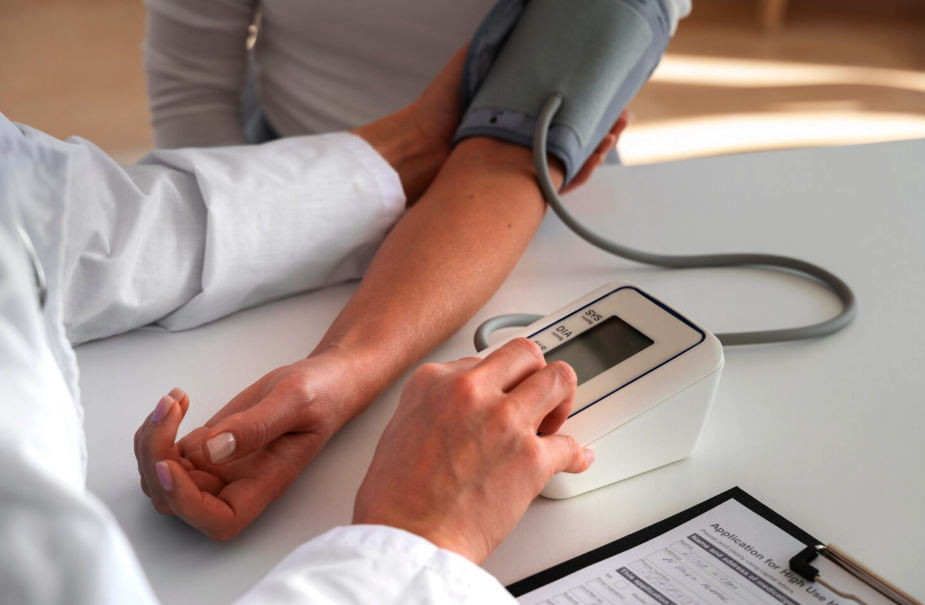 Doctor checking a patient's blood pressure with an arm cuff device