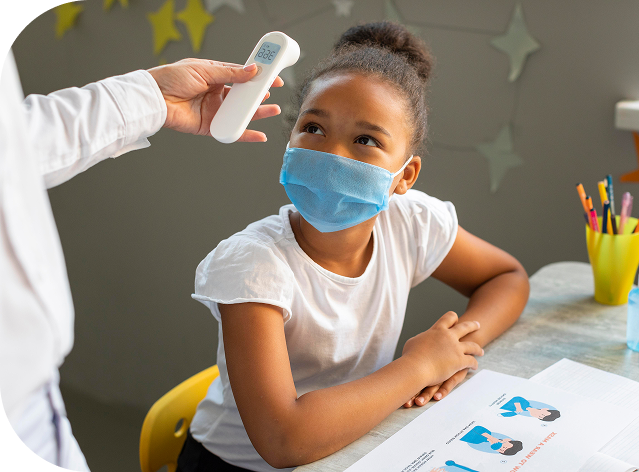 Healthcare provider checking a young girl's temperature with a forehead thermometer
