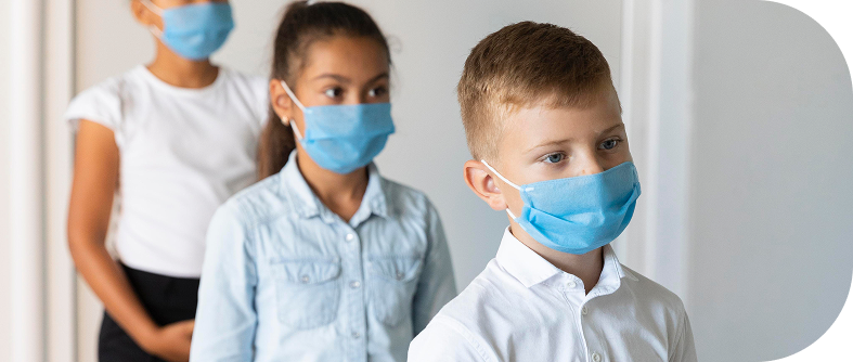 Three children wearing protective face masks standing in a line