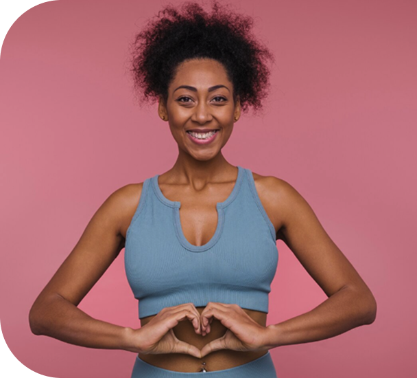 Woman in workout clothes making a heart shape with her hands over her stomach