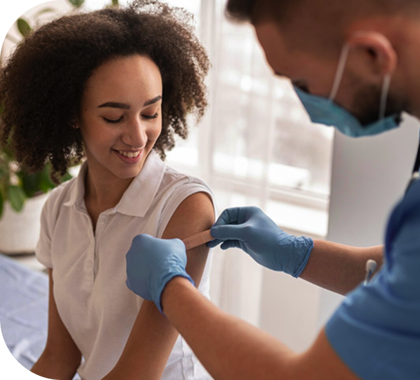 Healthcare provider applying a bandage to a young woman's arm after an injection